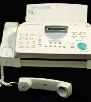 On a well used fax machine with room for copy. On a black background.