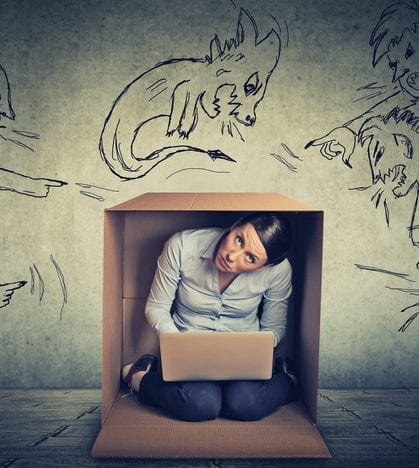 Bad evil men pointing at stressed woman. Desperate scared businesswoman hiding in a box working on laptop grey office wall background. Negative human emotions face expression feelings life perception