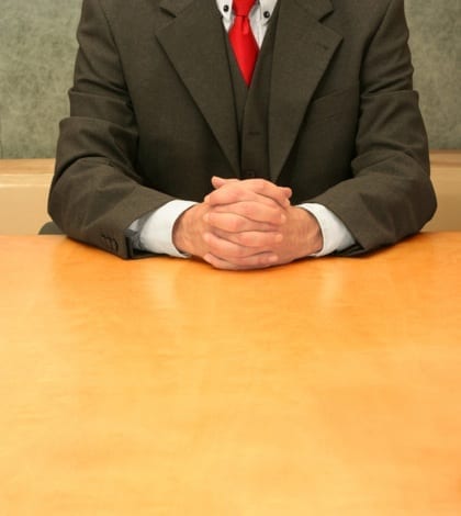 Office: trust me Business-man sitting at the desk, hands crossed.