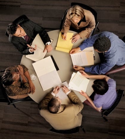 power meeting from above group of confident professional employees in a serious meeting from above