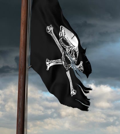 Tattered pirate flag flying high on a windy day