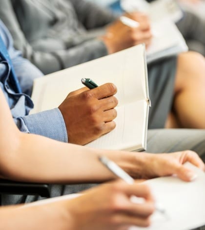 Unrecognizable people sitting in a row holding pens, notebooks and writing. 

[url=http://www.istockphoto.com/search/lightbox/9786622][img]http://dl.dropbox.com/u/40117171/business.jpg[/img][/url]