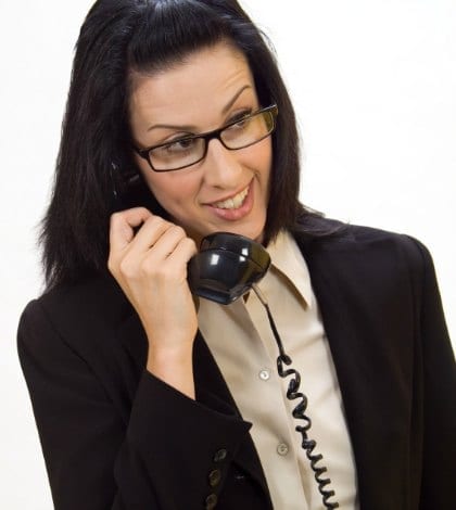 Woman holding an old school phone smiling Woman holding an old school phone smiling