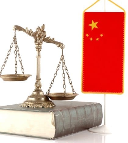 Decorative Scales of Justice on the book with Chinese flag on white. Law and order concept