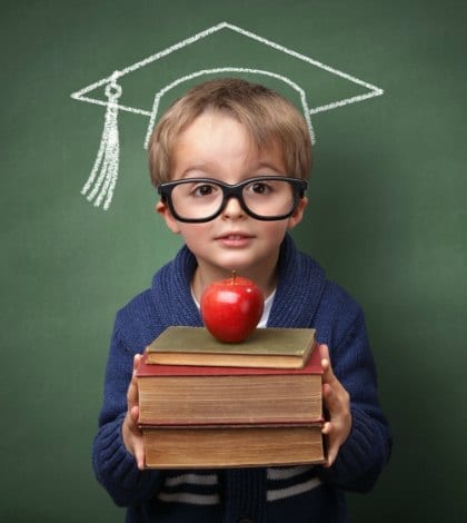 SMART KID_000040983796 420 Child holding stack of books with mortar board chalk drawing on blackboard concept for university education and future aspirations