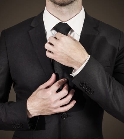 businessman in black suit correcting his black tie fashion