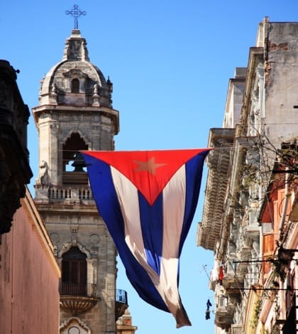 Cuban flag hanging between buildings in Havana, Cuba