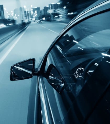 Car driving through the city at night.