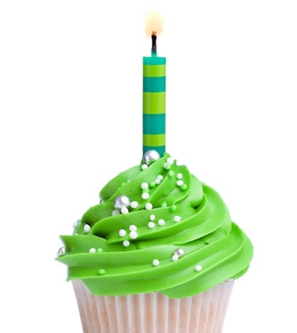 Cupcake decorated with green frosting and a single candle