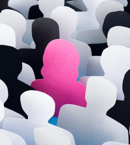Woman standing out Paper men silhouettes with one of a woman in between standing out from the rest