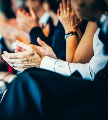What a great speech! Group of businesspeople sitting in a row and applauding at seminar. Selective focus.