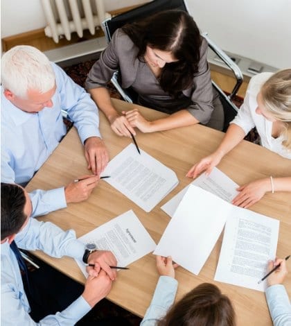 Lawyers working conference 577643982 420 Lawyers having team meeting in law firm reading documents and negotiating agreements