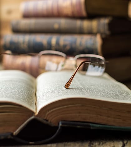 Old Glasses on Open Book, on Wooden Table Old Glasses on Open Book, on Wooden Table