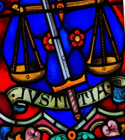 Stained Glass window representing Justice, symbolized by sword and balance, in the Cathedral of Saint Rumbold in Mechelen, Belgium.