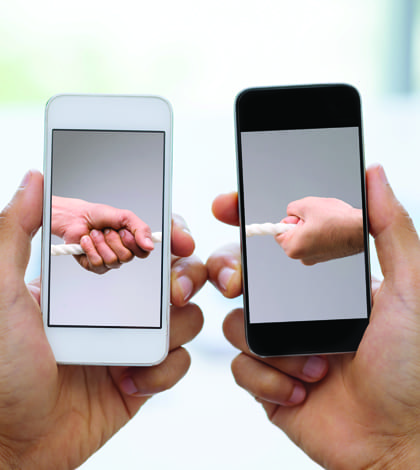 Two smartphones with male hands pulling tug of war