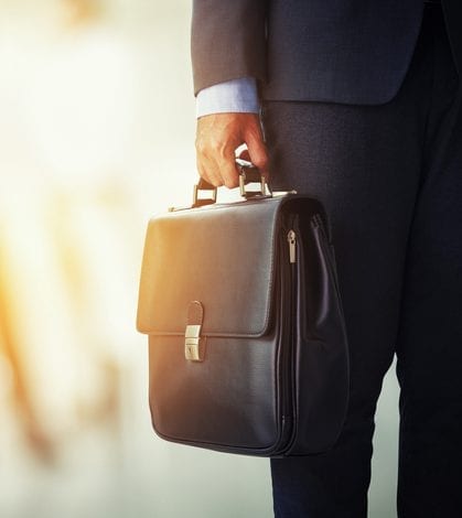 businessman holding his briefcase in office businessman holding his briefcase in office