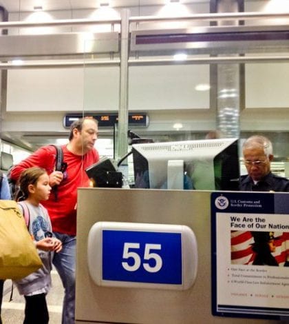 U.S. Immigration officer checking documents of tourists "Los Angeles, USA - April 28, 2013: U.S. Immigration officer checking documents of family of tourists arrived in Los Angeles. U.S. Customs at Los Angeles Airport"