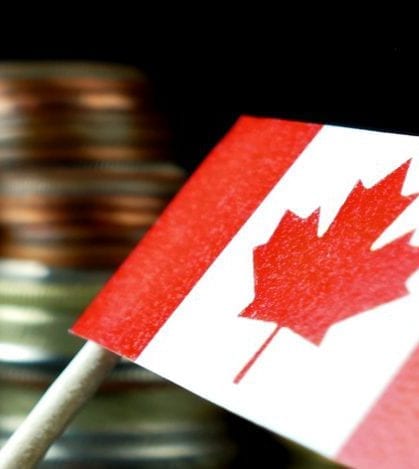 Canada flag waving with stack of money coins macro Canada flag waving with stack of money coins macro