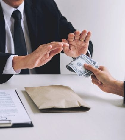 Bribery and corruption concept, senior businessman manager refusing receive money in the envelope to agreement contract, A bribe in the form of dollar bills Bribery and corruption concept, senior businessman manager refusing receive money in the envelope to agreement contract, A bribe in the form of dollar bills.