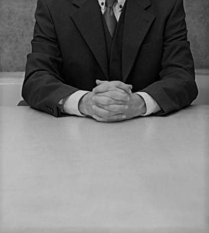 Office: trust me Business-man sitting at the desk, hands crossed.
