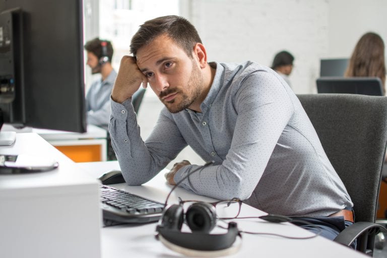 Worried beard man looking at computer screen in office Worried beard man looking at computer screen in office