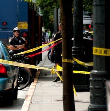 Seattle, USA - August 12, 2013:  Police CSI officers gathered outside a cruiser investigating a shooting aboard a Seattle bus on 3rd ave in Downtown during the morning Commute.