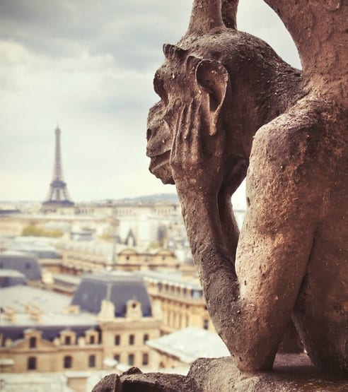 Paris city with Eiffel tower seen from Notre Dame roof Paris view with Eiffel tower seen from the Notre Dame cathedral with detail of Gargoyle statue