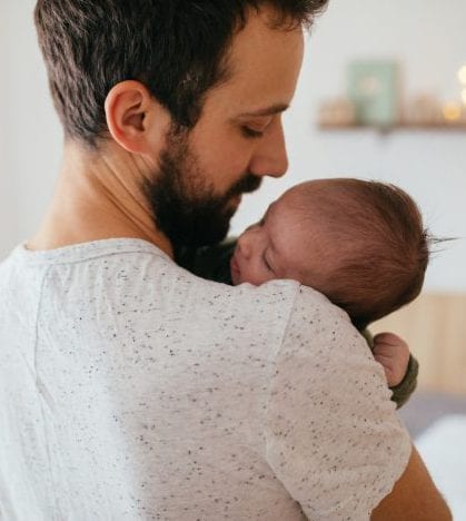 Father putting his baby to sleep Photo of a young father holding his newborn son, singing some lullabies while putting him to sleep