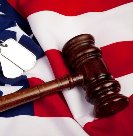 Gavel And Dog Tag On American Flag for "war crimes" concept and veteran rights