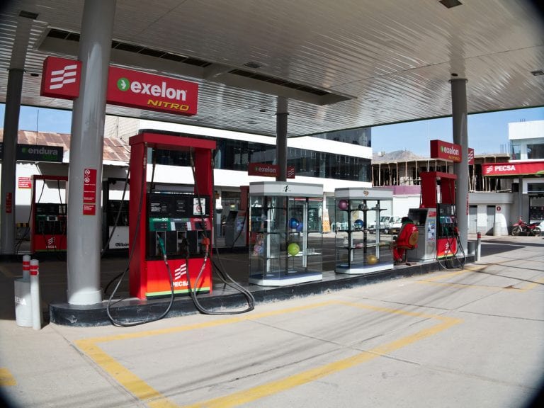 Cuzco, Peru - June 1, 2013: Exelon brand Peruvian gas station on a Cuzco City street . Workers and customers are standing and walking on the garage forecourt.