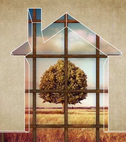 The house becomes a prison - House arrest on residential building - concept image with the graphic outline of a small home closed by a metal railing towards a rural scene with a tree.