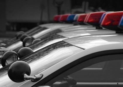 Copland A fleet of black and white police cars with the red, white, and blue lights atop.