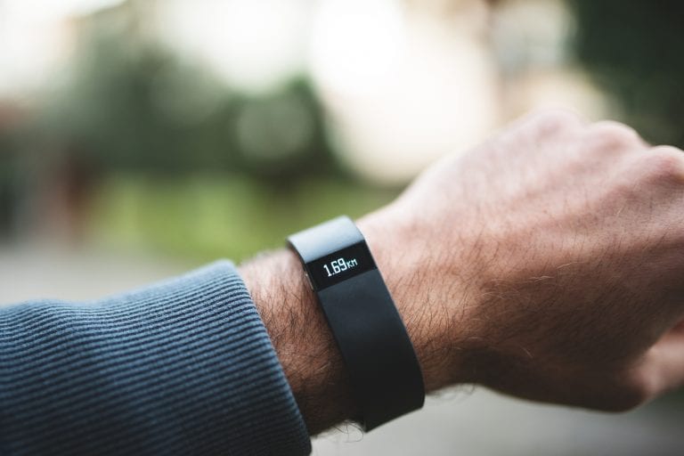 New Fitbit Force, sport fitness tracker Florence, Italy - January 26, 2014: Close up of the new Fitbit Force on the wrist of a guy. Fitbit Force is the new sport fitness tracker that can allow to track your daily activity, calories burned, sleep & weight, and with that is it possible the upload wirelessly & see progress on mobile and online dashboard. The bracelet is showing the number of daily kms done. image taken outdoor.