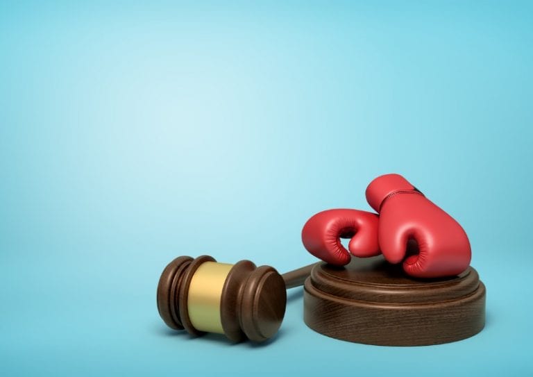 3d-rendering-of-red-boxing-gloves-on-round-wooden-block-and-brown-picture-id1180983855 Legal Fight