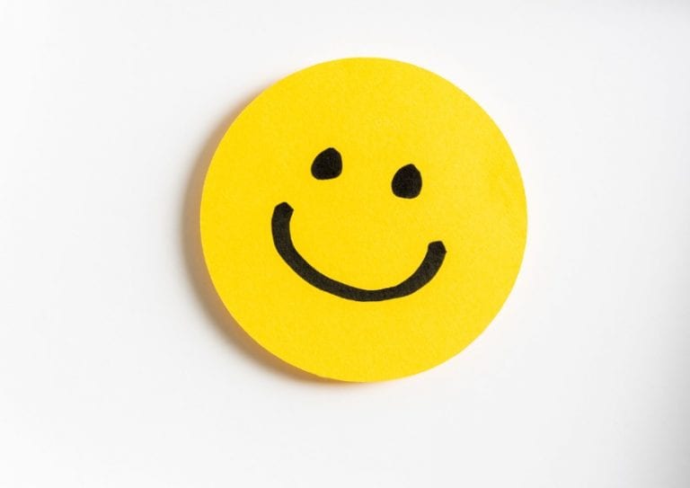 drawing-of-a-happy-smiling-emoticon-on-a-yellow-paper-and-white-picture-id1171346911