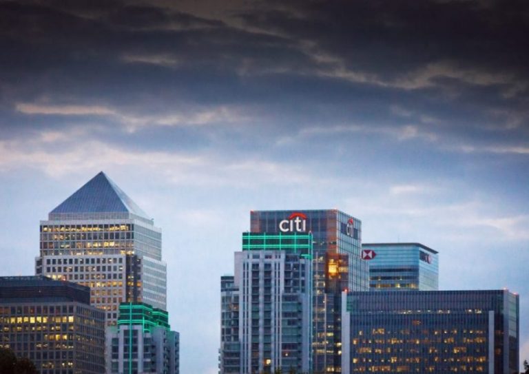 London Canary Wharf Skyline at sunset London, United Kingdom - August 20, 2014: The London Canary Wharf skyline viewed from Greenwich near the Cutty Sark, showing the illuminated signs on the buildings.