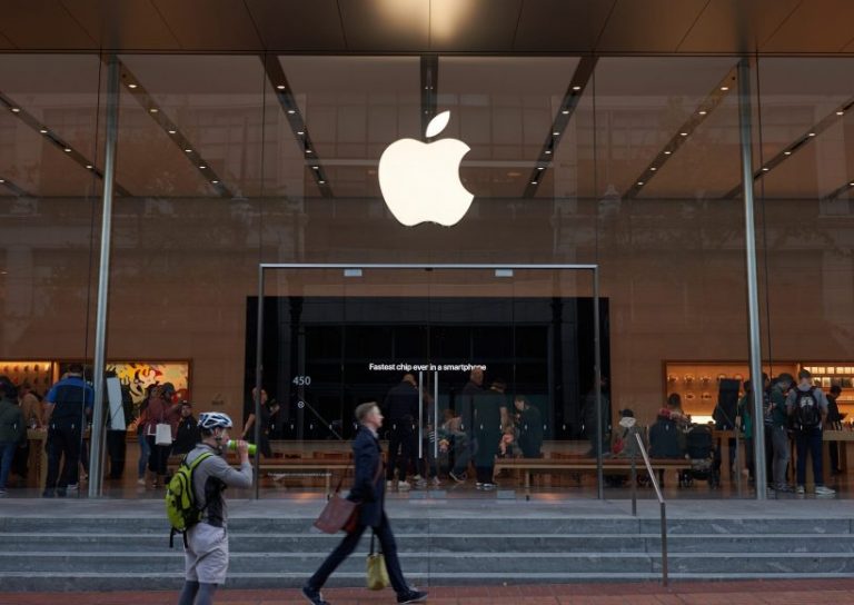 Apple Store in Downtown Portland Portland, Oregon, USA - Oct 1, 2019: A man strides past an Apple Store in downtown Portland. The big screen inside is seen advertising Apple's fastest A13 Bionic chips in the new iPhone series.