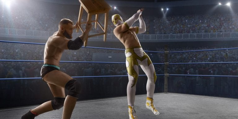 Wrestling show. Two wrestlers in a bright sport clothes and face mask fight in the ring Wrestling show. Two wrestlers in a bright sport clothes and face mask fight in professional ring. One athlete strikes the second man with a chair. The enemy attacks with a bat.
