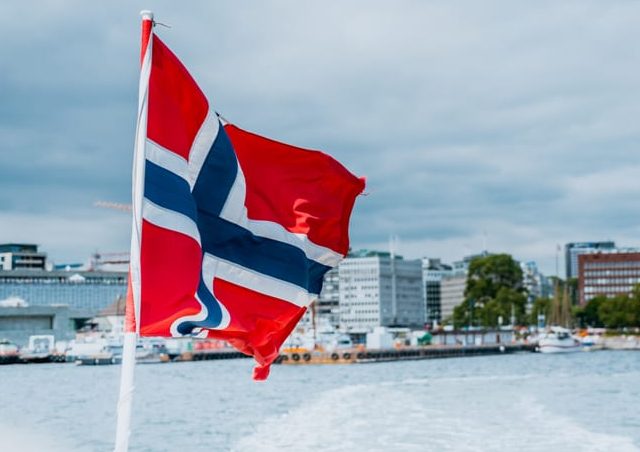 Norway flag on the ferry, view of Oslo city hall, Scandinavia Norway flag on the ferry, view of Oslo city hall, Scandinavia