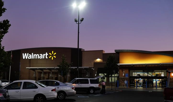 Folsom, California, USA - August 13, 2016: Approaching entrance of Walmart Superstore in Folsom, California, at twilight hour while customers are going in and out of the store.