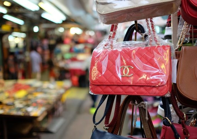 Kuala Lumpur, Malaysia - August 19, 2015: Some fake bags on sale in China Town market in Kuala Lumpur. In this area it is full of small shops selling a plenty of counterfeit merchandise illegally. This area is popular among tourist, and sometimes they are not aware that buying these fake goods is illegal and may lead to problems at the customs.