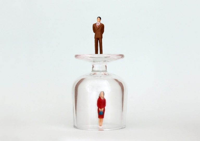 miniature-woman-in-a-glass-cup-and-a-miniature-man-on-top-of-a-glass-picture-id954079320