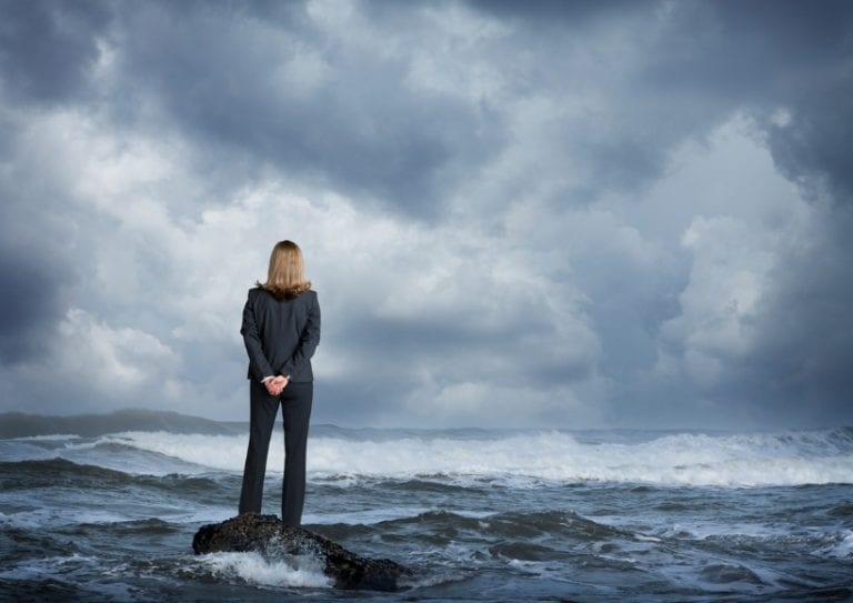 businesswoman-standing-in-rough-ocean-surf-picture-id698120994