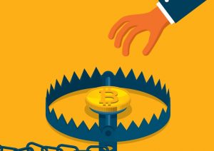 Hand reaches towards bitcoin sitting in a trap