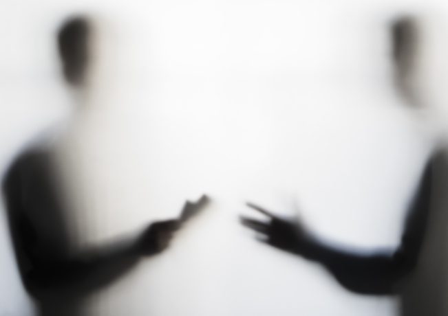 Two men negotiating behind curtain Two partially obscured figures talking or gesturing at each other, as if in discussion.