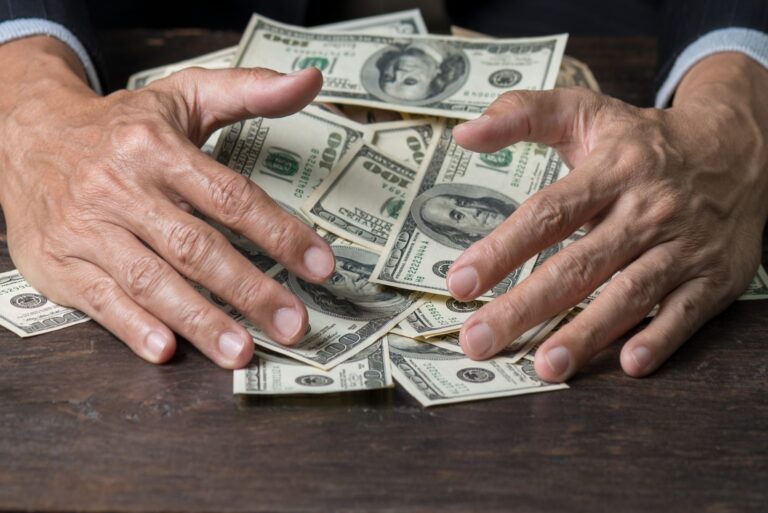 Man hands sweeping money,business concept. Man hands sweeping money,business concept. Lucky man winning lots of us dollar from gambling,with smiling face and black background.