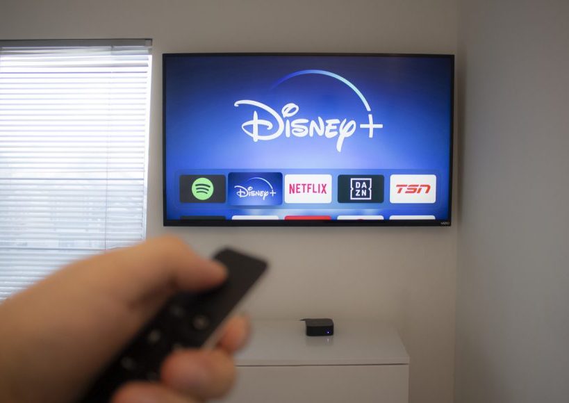 Calgary, Alberta. Canada Dec 5 2019: Person holds an Apple TV remote using the new Disney+ app on a Vizio TV. Disney+ video streaming service will exclusively show Star Wars: Jedi Template Challenge.
