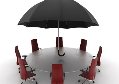 Umbrella Conference table _web Umbrella over empty chairs around a conference table.