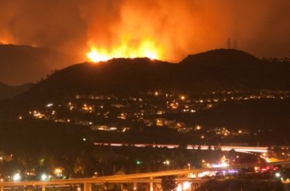 WILD FIRE urban 000012377295 420 Wildfire in distant hills at night, city and city lights in foreground.