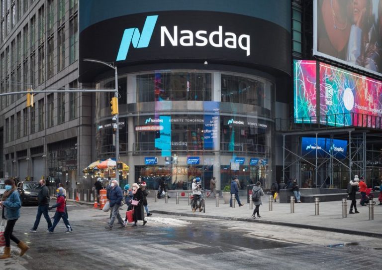 New York during the COVID-19 emergency. Manhattan, New York. December 23, 2020. People walking in front of Nasdaq market site located at 4 Times Square.
